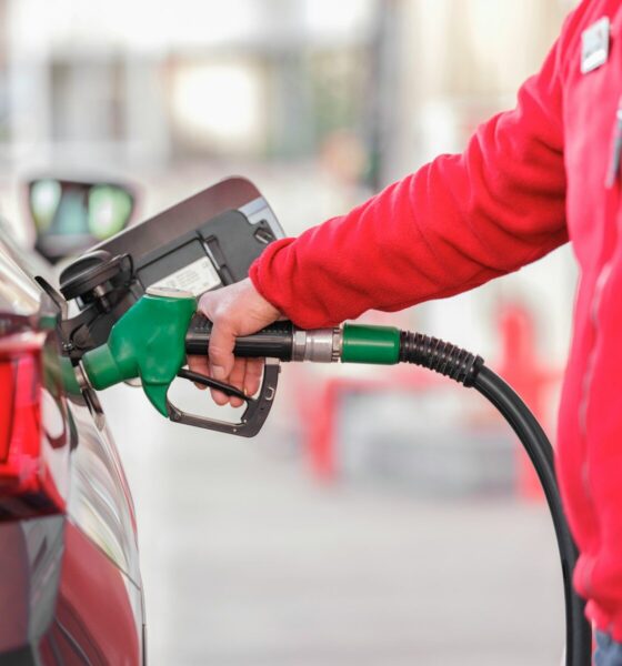 a person filling a car with gas at a gas station